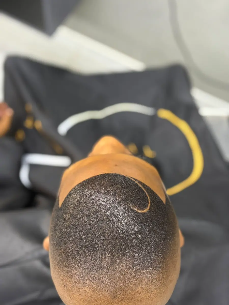 Close-up of a short fade haircut with a curved shaved design